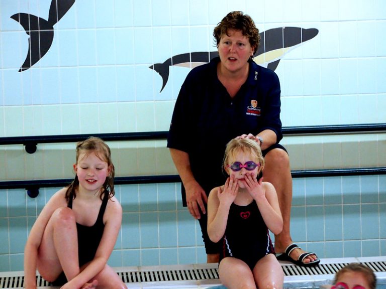 Teacher with kids by the edge of the pool